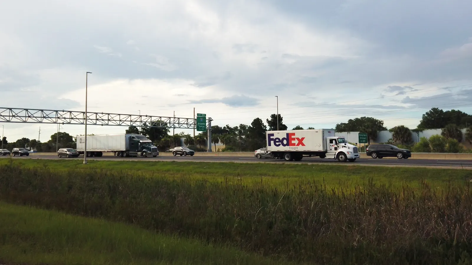 Highway traffic with trucks and cars driving by on a Florida road